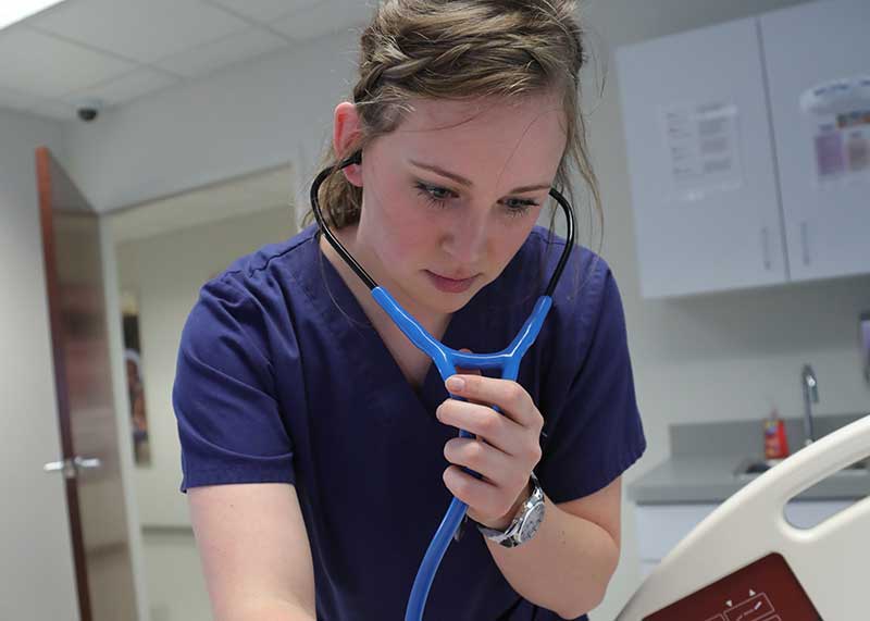 Lauren Xavier ABSN student using stethoscope